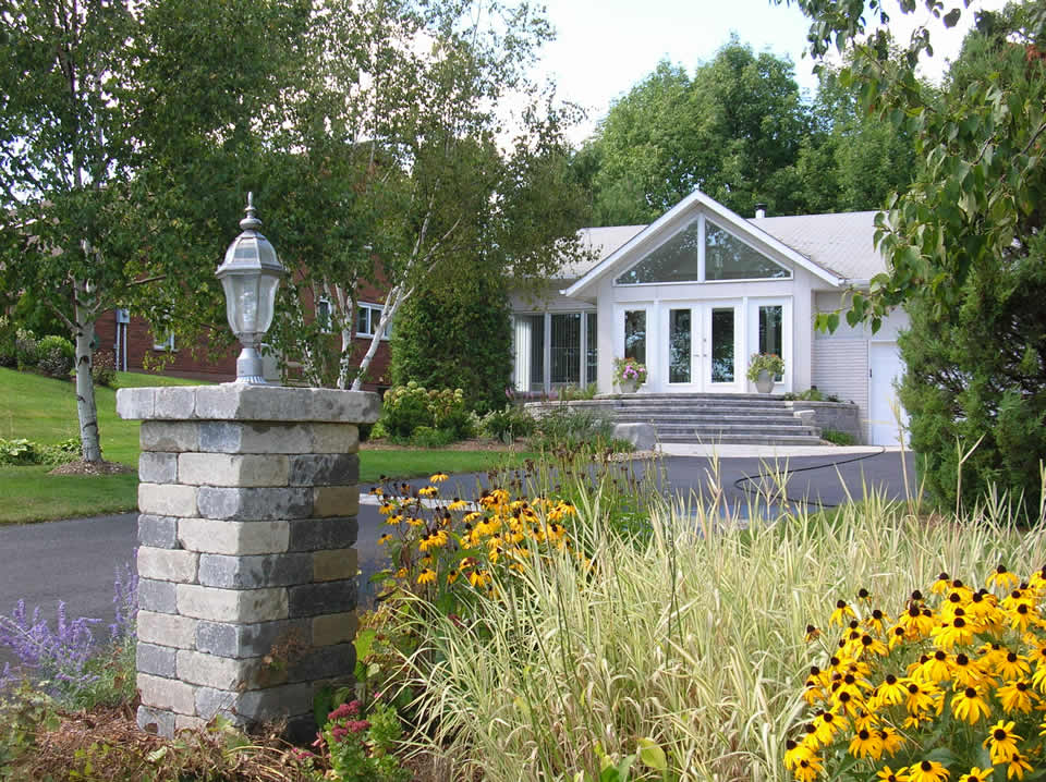 Brown-eyed susan, ornamental grass, and stone pillar with lighting