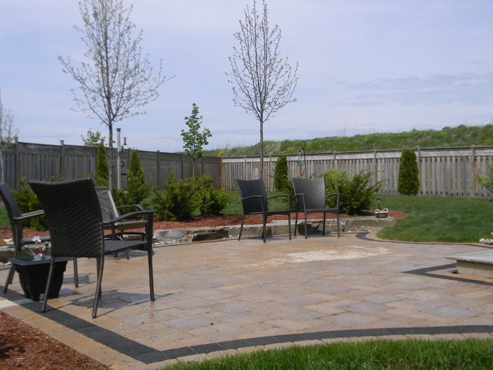 Backyard with natural stone, plantings and interlock patio