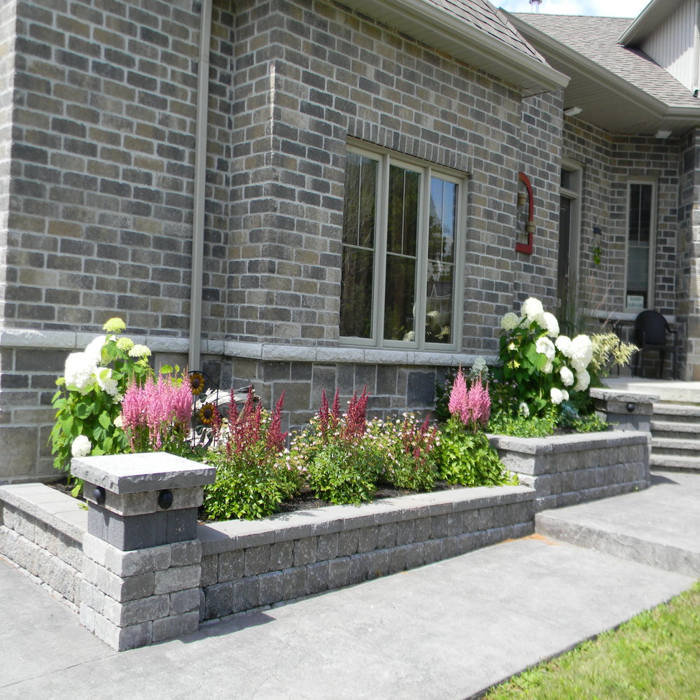 Stone pillars with planter walls.  Astilbes and Annabelle Hydrangeas in flower